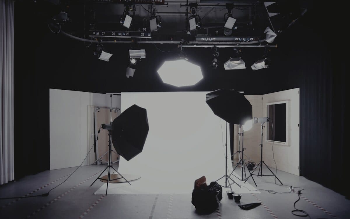 A lighting truss over a set, fixtures rigged along it and warm light spilling out underneath